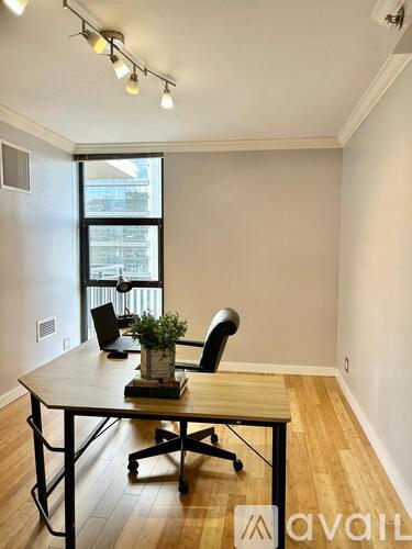 A room with a desk and a chair in front of a window.