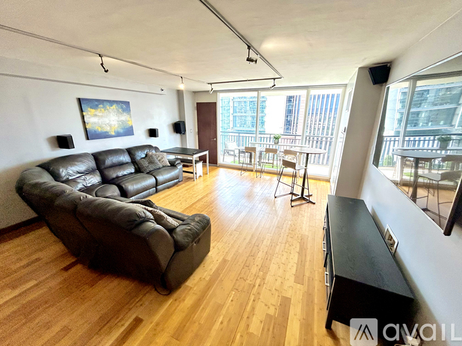 A living room with a large leather sofa and wooden flooring.