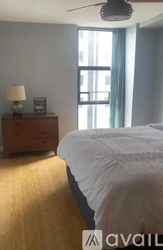 A bedroom with a bed, dresser, and window.