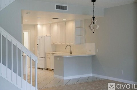 A kitchen with white cabinets and a white sink.