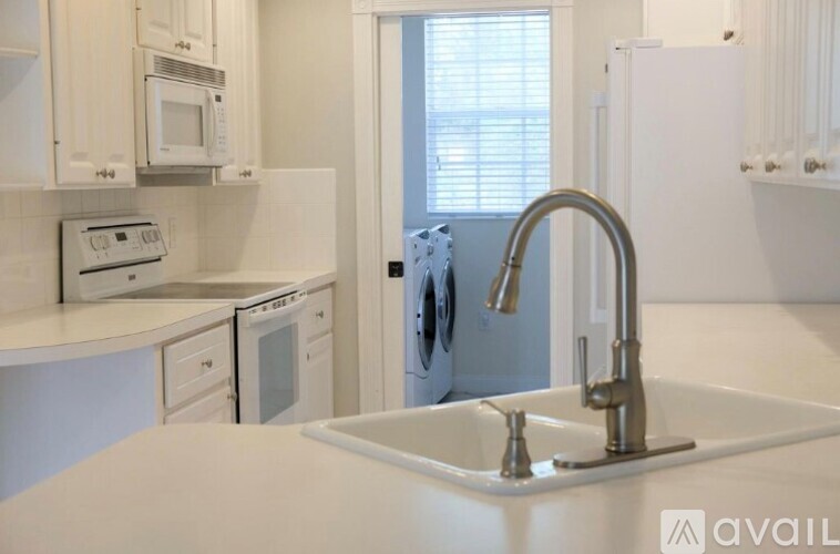 A kitchen with white appliances and a white sink.