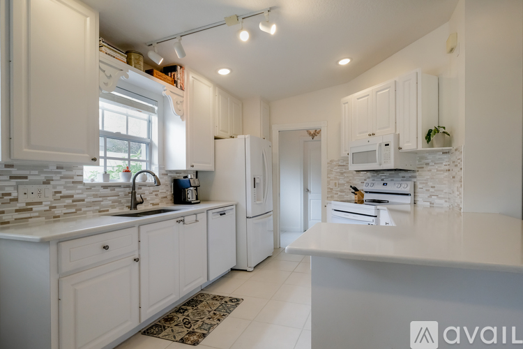 A kitchen with white cabinets and appliances.