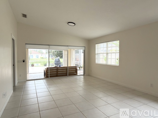 A spacious living room with white walls and a large window.