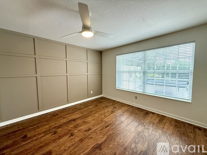 A room with a ceiling fan and a window with blinds.