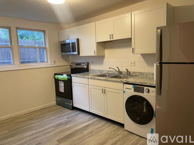 A kitchen with a washing machine and a refrigerator.