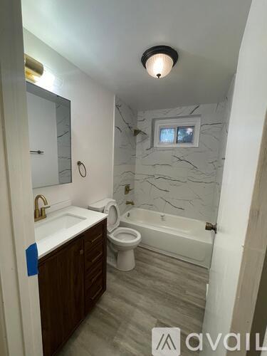 A bathroom with a toilet, sink, and bathtub.