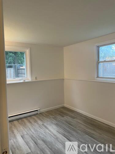 A room with a window and a radiator on the floor.