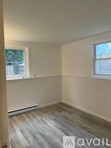 A room with a window and a radiator on the floor.