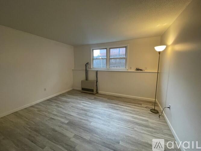 A room with a grey floor and a window with a white frame.