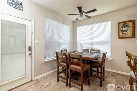 A dining room with a table and chairs.