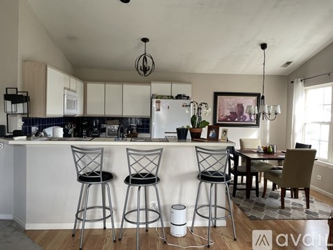 A kitchen with white cabinets and a white refrigerator.