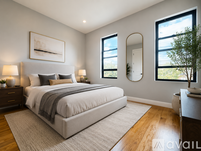A bedroom with a large bed and a view of the outdoors through a window.