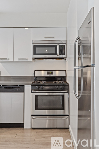 A kitchen with a stainless steel refrigerator, oven, and microwave.