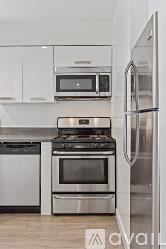 A kitchen with a stainless steel refrigerator, oven, and microwave.