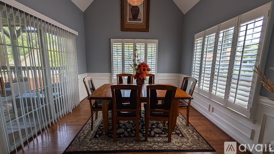 A dining room with a wooden table and chairs.