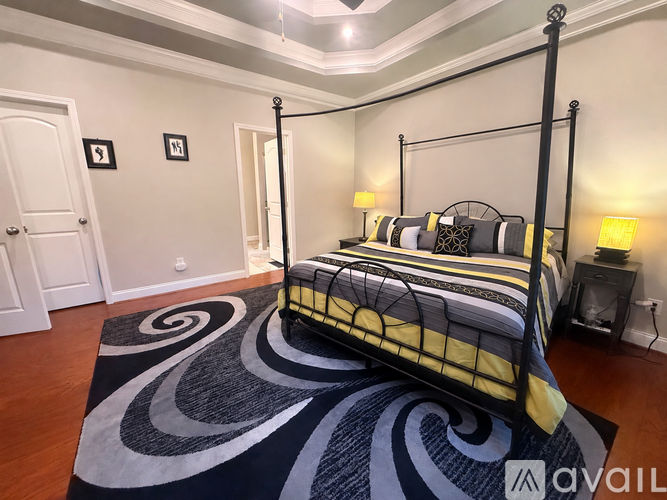A bedroom with a black and yellow bed and a black and white rug.
