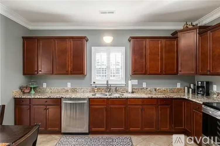 A kitchen with brown cabinets and a granite countertop.