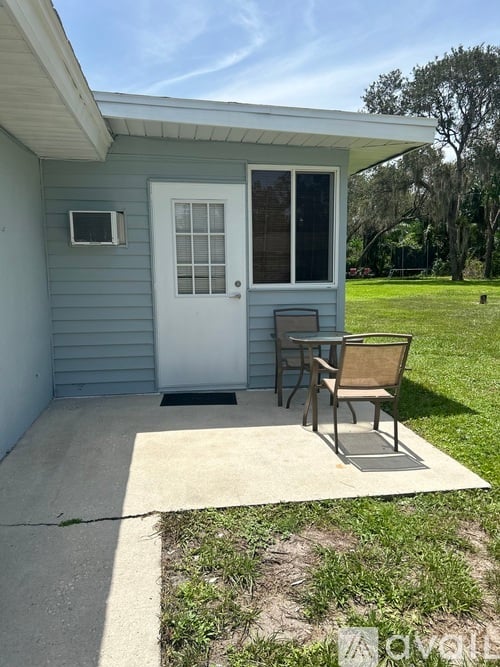 A small house with a white door and a small porch.