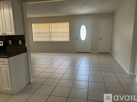 A kitchen with white cabinets and a black countertop.