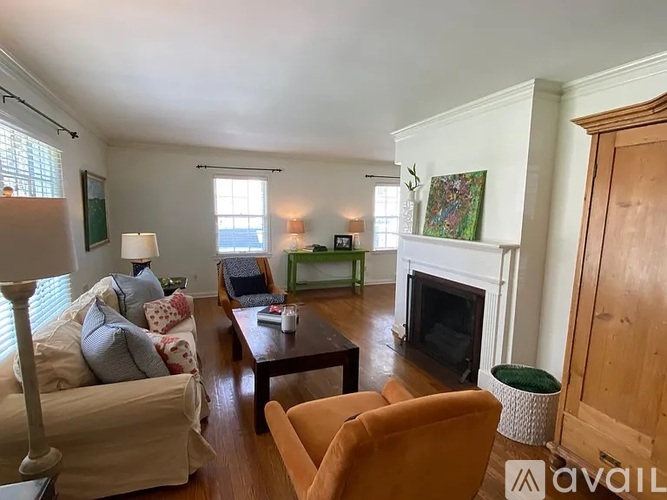A living room with a fireplace and a painting on the wall.