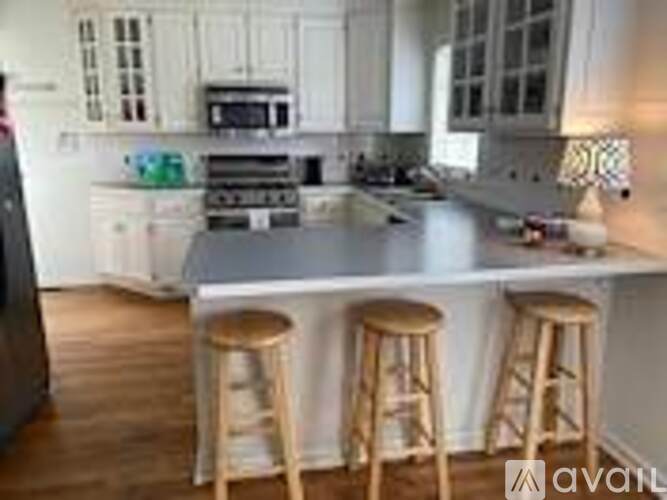 A kitchen with white cabinets and a wooden floor.