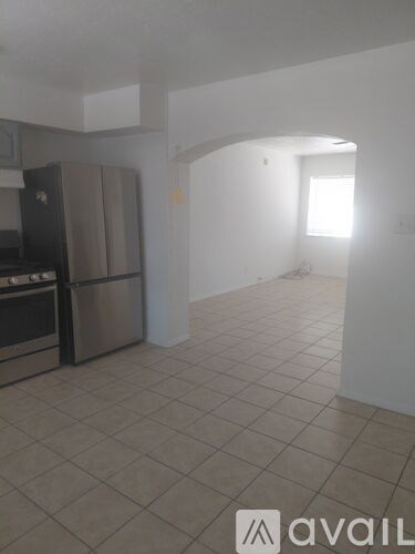 A kitchen area with a refrigerator and a sink.