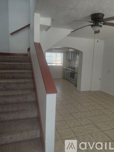 A staircase with a carpeted runner and a wooden handrail.