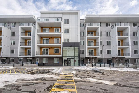 A large white apartment building with a yellow line in front.
