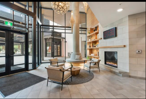 A modern living room with a fireplace and a green exit sign.