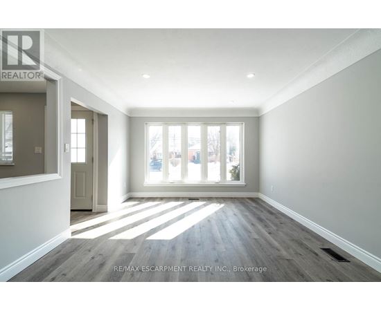 A spacious room with a view of the city through the windows.
