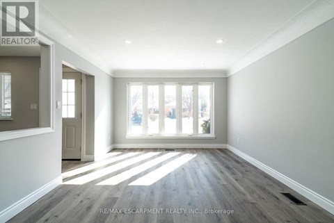 A spacious room with a view of the city through the windows.
