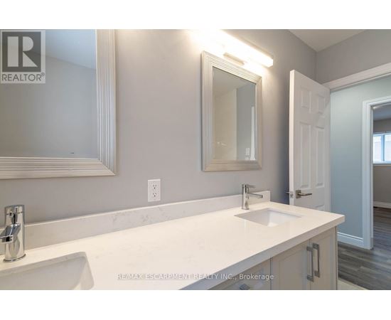 A bathroom with a white sink and a mirror above it.
