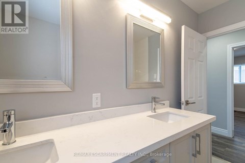 A bathroom with a white sink and a mirror above it.