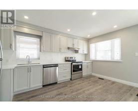 A kitchen with white cabinets and a stainless steel dishwasher and oven.
