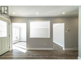 A spacious room with a large window and a door on the left.