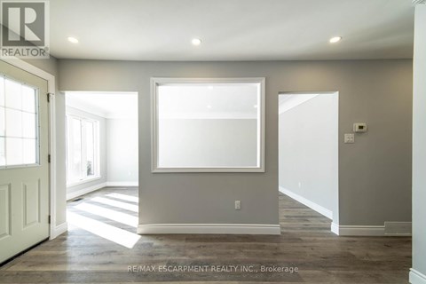 A spacious room with a large window and a door on the left.