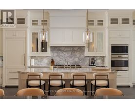 A kitchen with white cabinets and a marble backsplash.
