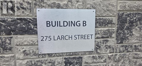 A sign on a brick wall that says Building B 275 Larch Street.