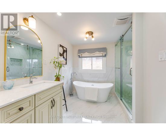 A bathroom with a white tub and a large mirror.