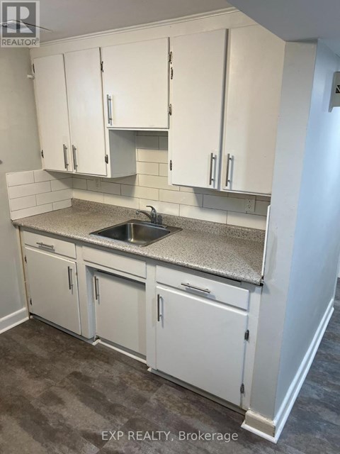 A kitchen with white cabinets and a granite countertop.