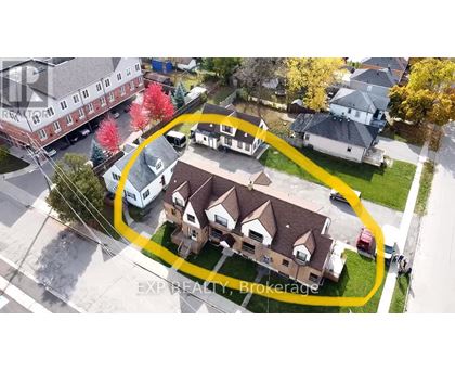 An aerial view of a neighborhood with a yellow circle highlighting a house for sale.