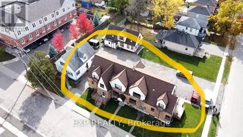 An aerial view of a neighborhood with a yellow circle highlighting a house for sale.