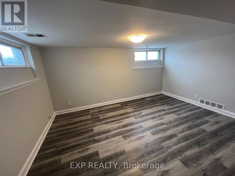 A room with wooden flooring and a window.