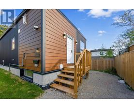 A small house with a wooden deck and a white door.