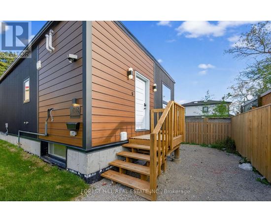 A small house with a wooden deck and a white door.
