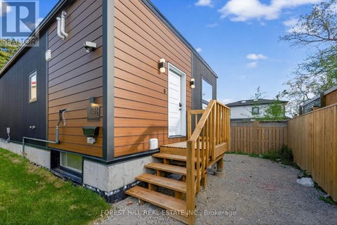 A small house with a wooden deck and a white door.