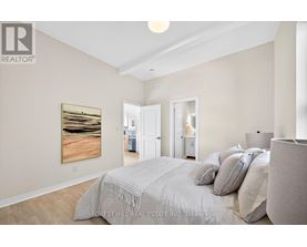 A bedroom with a large bed and a painting on the wall.