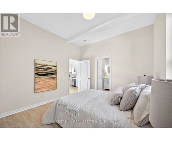 A bedroom with a large bed and a painting on the wall.