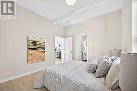 A bedroom with a large bed and a painting on the wall.