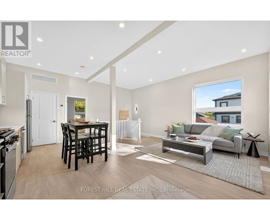A modern living room with a dining area and kitchen in the background.
